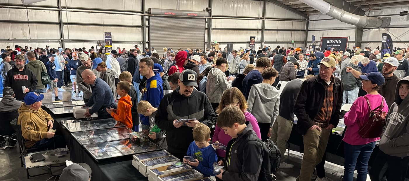 A packed show floor at Pikes Peak Card Show — collectors and families browsing display cases and dollar boxes down every aisle